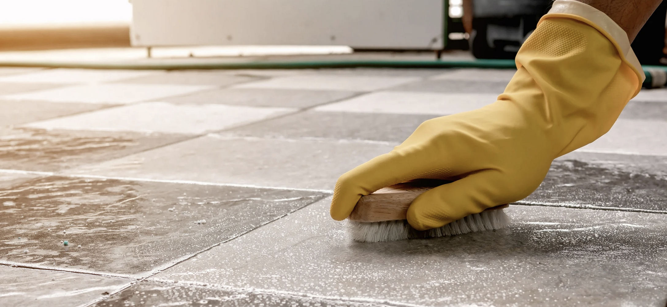 person scrubbing the floor with brush